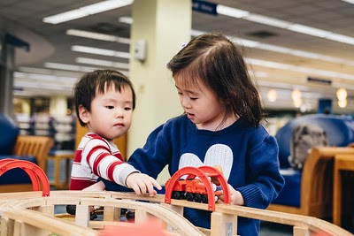 Two preschoolers playing at the train table